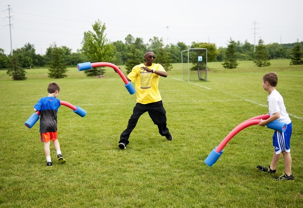 Pittsfield Pee Wee Olympics volunteer Michael Scott plays with kids in the jousting area on Sunday, June 9. Daniel Brenner I AnnArbor.com